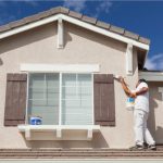 House Painter Painting the Trim and Shutters of Home